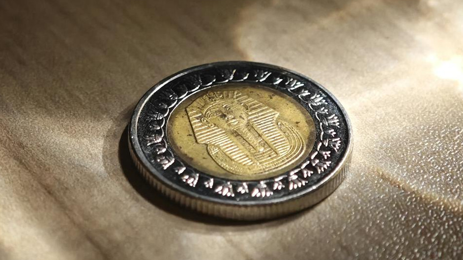 An Egyptian one-pound coin placed on a reflective surface, symbolizing Egypt’s financial reforms and the economic impact of the new Tax Incentive Law for SMEs.