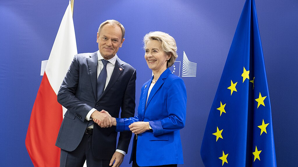 Polish leader Donald Tusk and EU Commission President Ursula von der Leyen shaking hands, symbolizing Poland’s strategic EU Council Presidency in 2025, focused on tax and customs reforms.