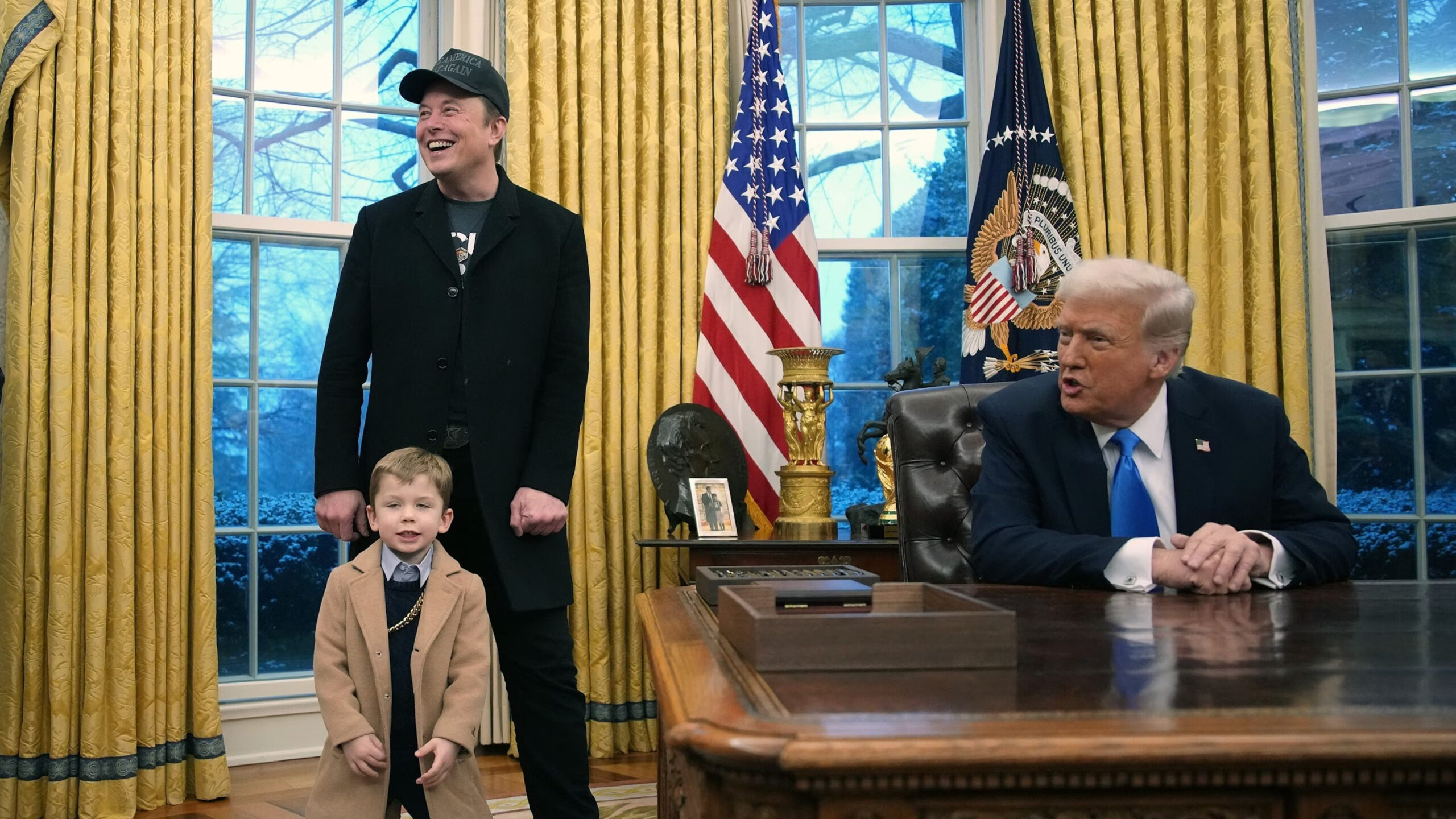 Elon Musk is with President Trump in the Oval Office as he signs an executive order that mandates all federal agencies work with DOGE.