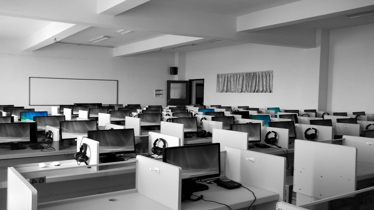 Black-and-white photo of empty office workstations symbolizing PwC’s 2025 U.S. workforce reduction and broader Big Four restructuring trends.